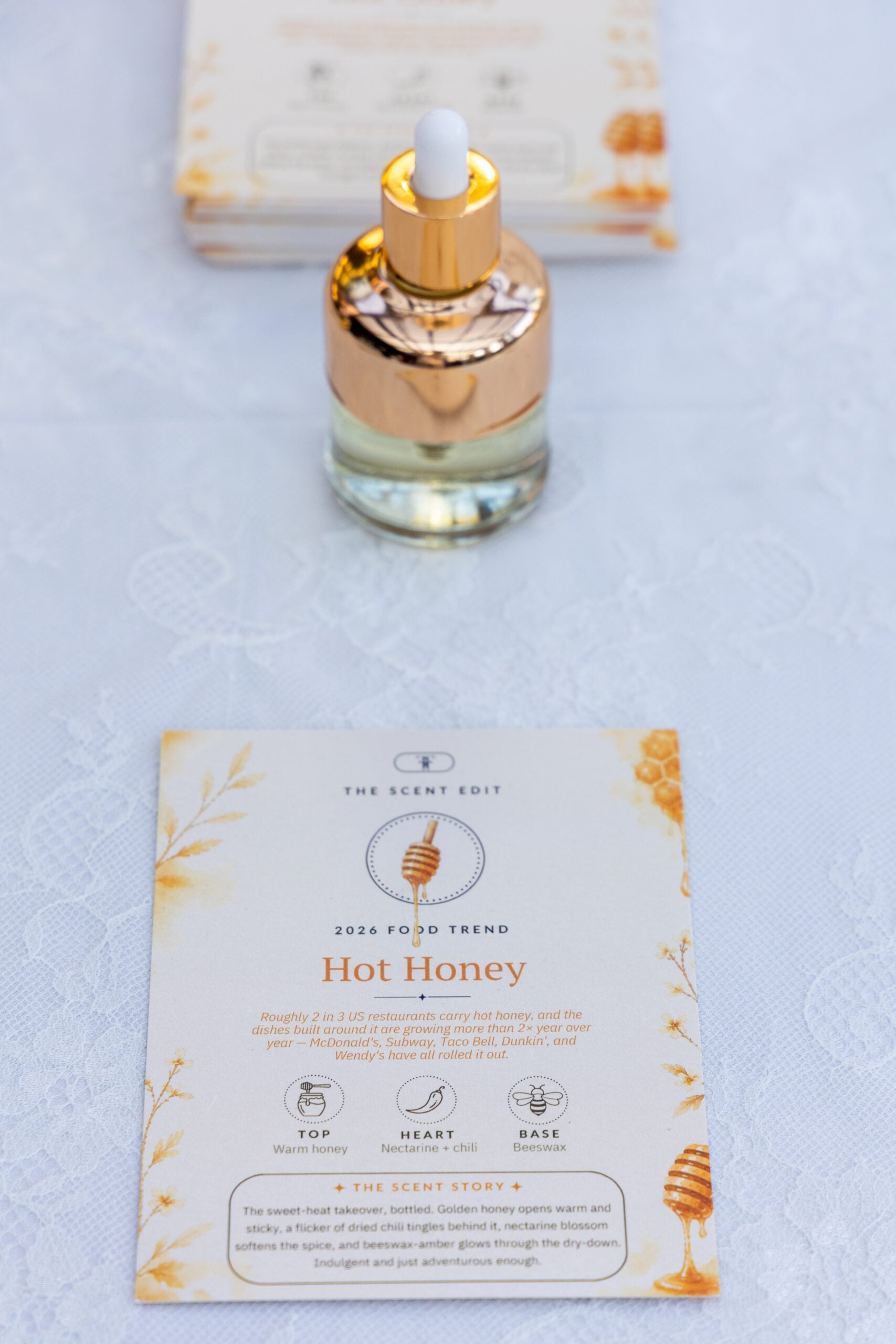 Gold dropper perfume bottle with a scent card on lace