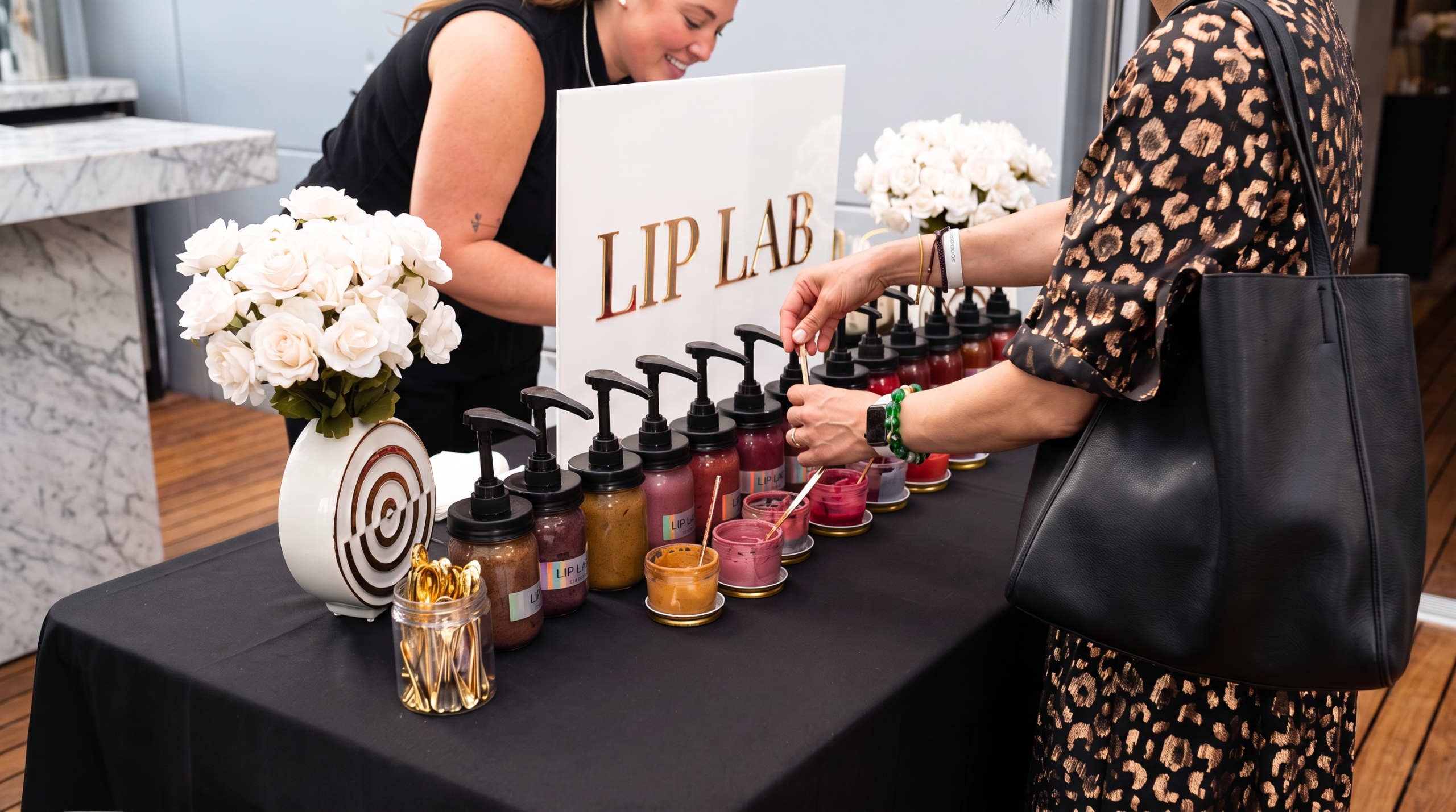 Corporate holiday party ideas: the Luxury Lip Lab station blending custom lip color shades