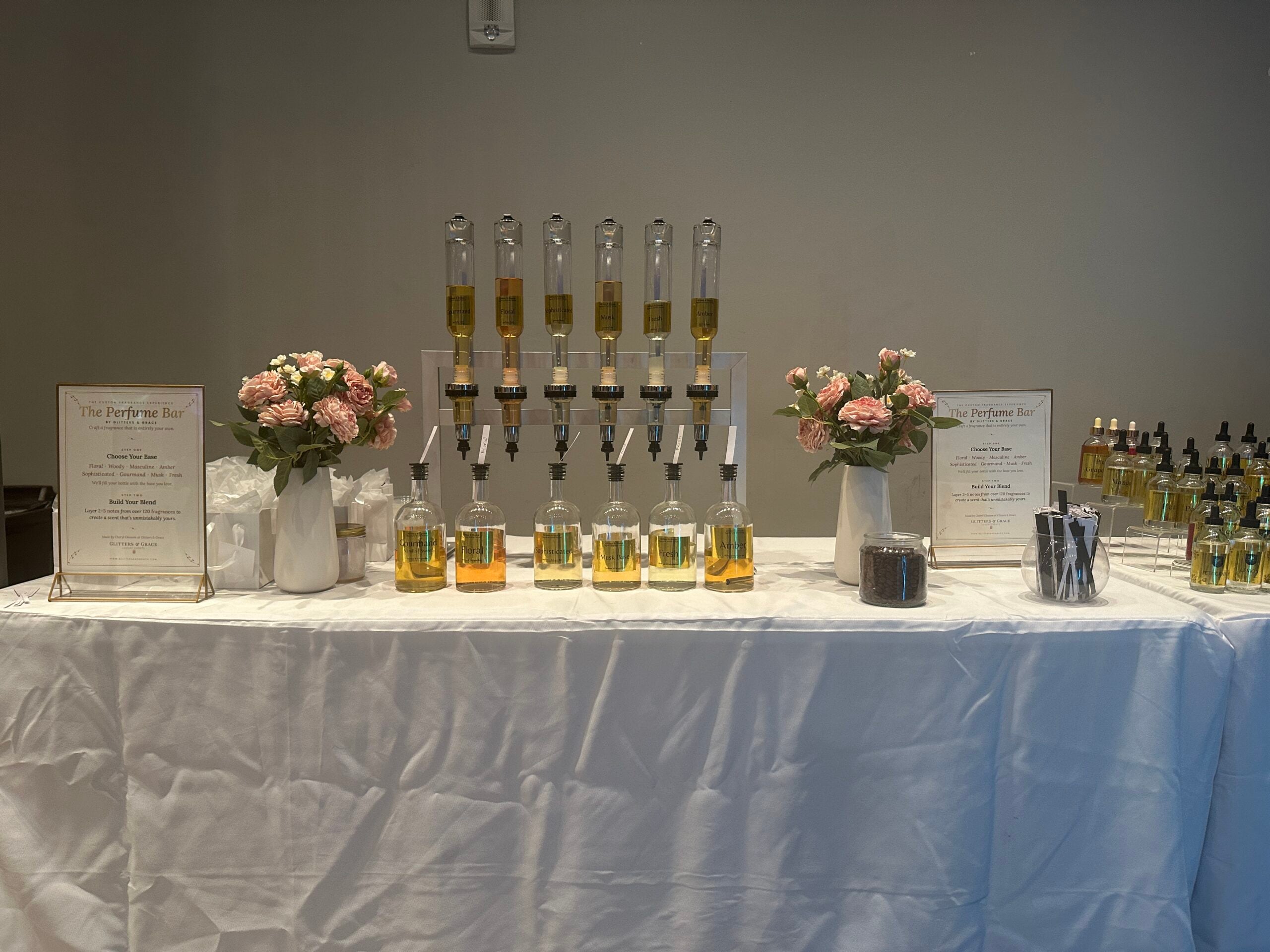 Perfume bar table with florals and a dispenser tower