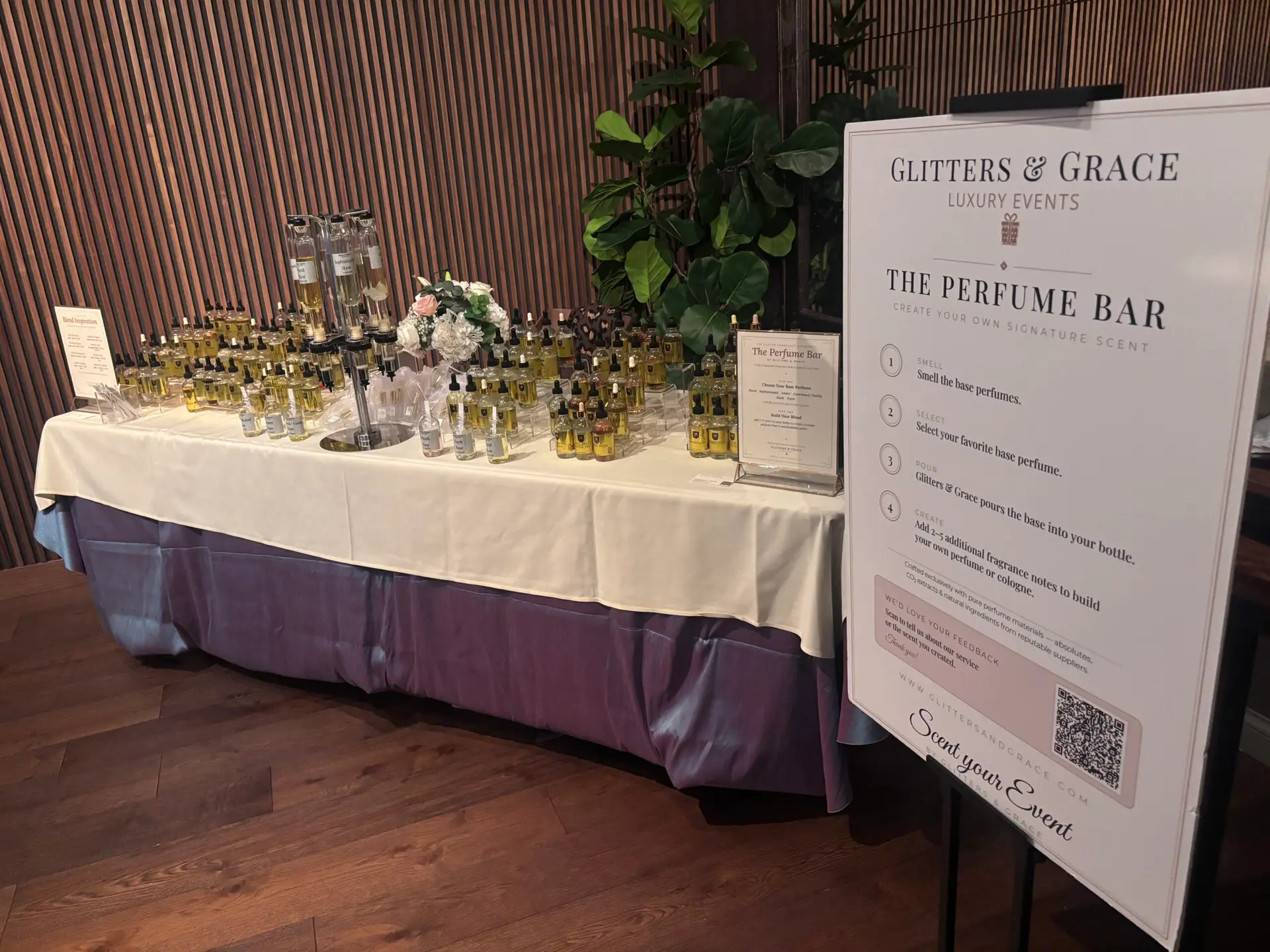 A Glitters and Grace blending bar with perfume bottles and signage