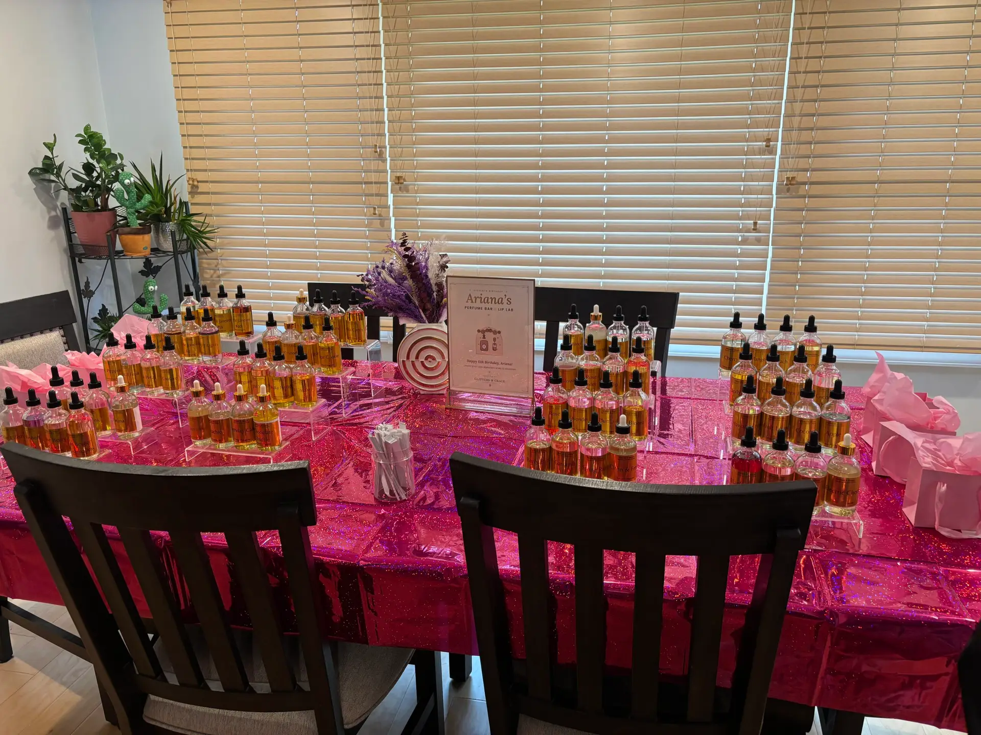 Kids perfume bar with pink linens and rows of bottles